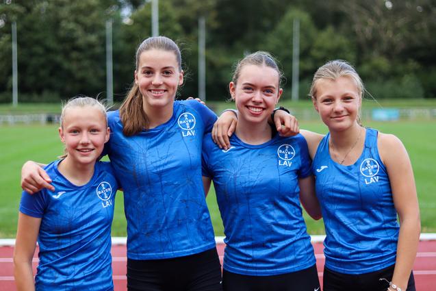 Vier Mädchen in blauen Oberteilen