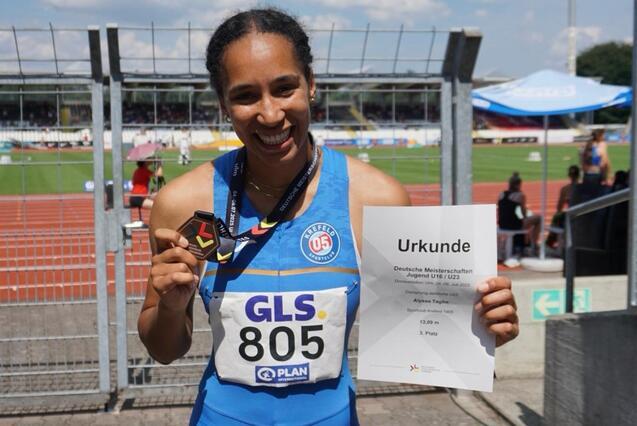 Sportlerin mit Medaille und Urkunde
