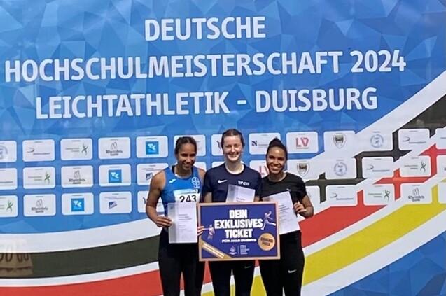Drei Leichathletinnen halten ein Schild hoch