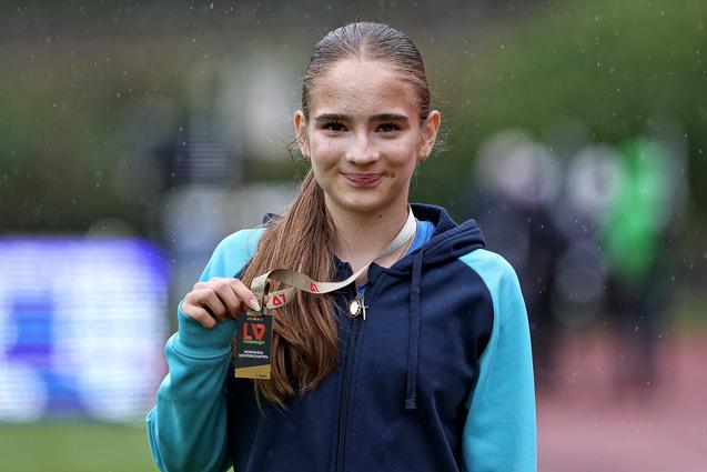 Eine Sportlerin zeigt ihre Medaille