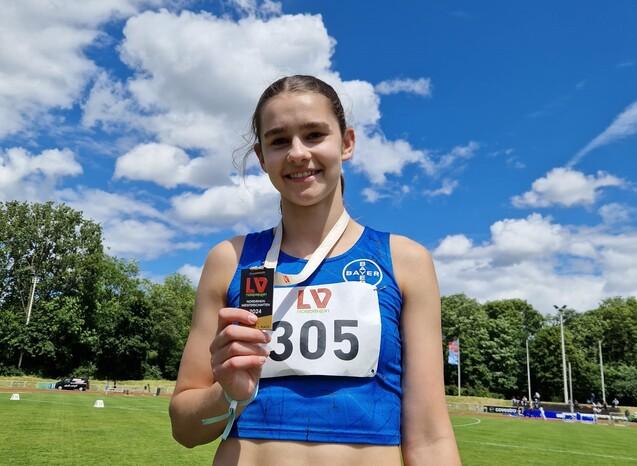 Eine Sportlerin zeigt ihre Medaille