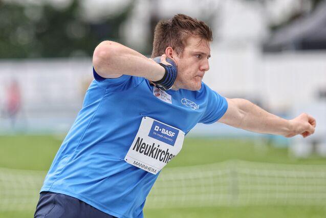 Angespannter Sportler beim Kugelstoßen