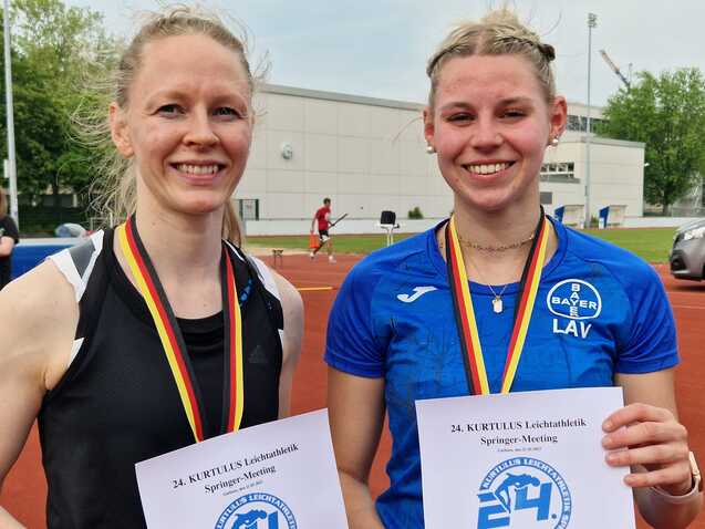 Zwei Sportlerinnen mit Medaillen und Urkunden