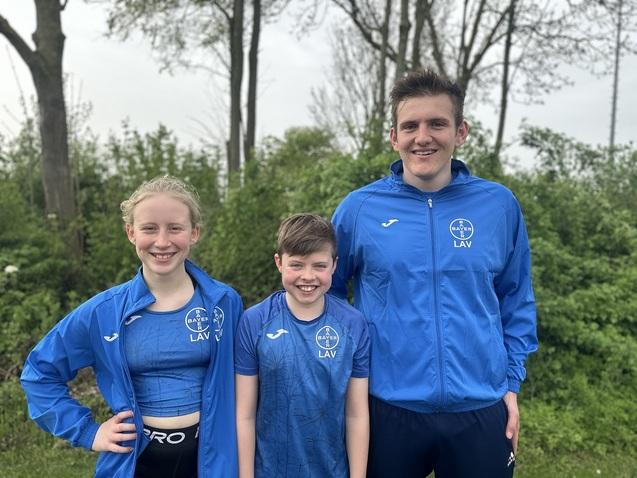 Drei Sportler'innen stehen zusammen