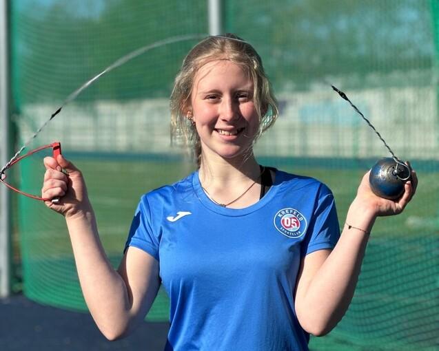 Sportlerin zeigt ihr Sportger&auml;t, einen Hammer