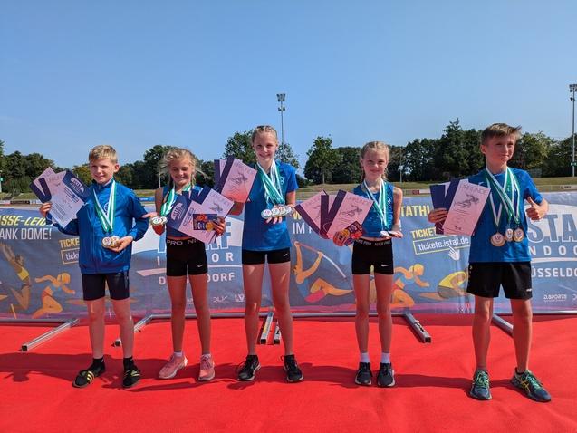 Fünf Sportler*innen mit Urkunden und Medaillen