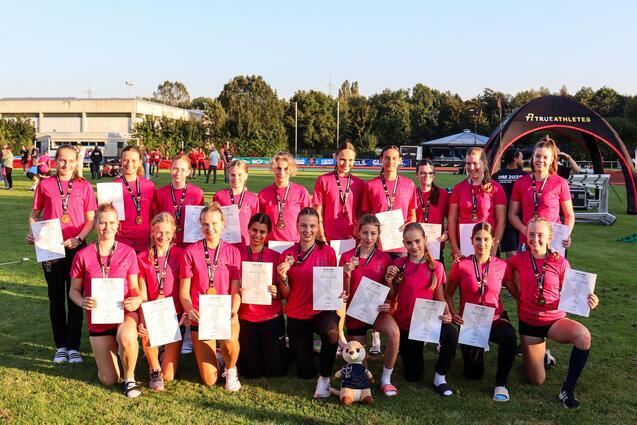 Team mit pinken Shirts und Urkunden