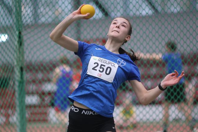 Sportlerin in einer Drehbewegung mit einem gelben Ball
