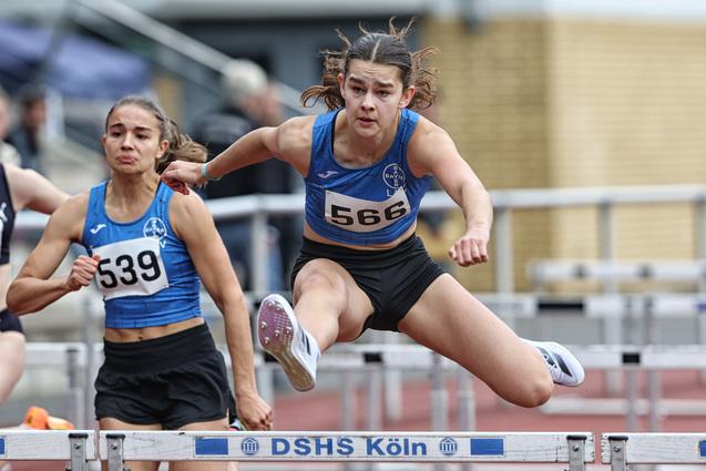 Leichtathletin springt über eine Hürde