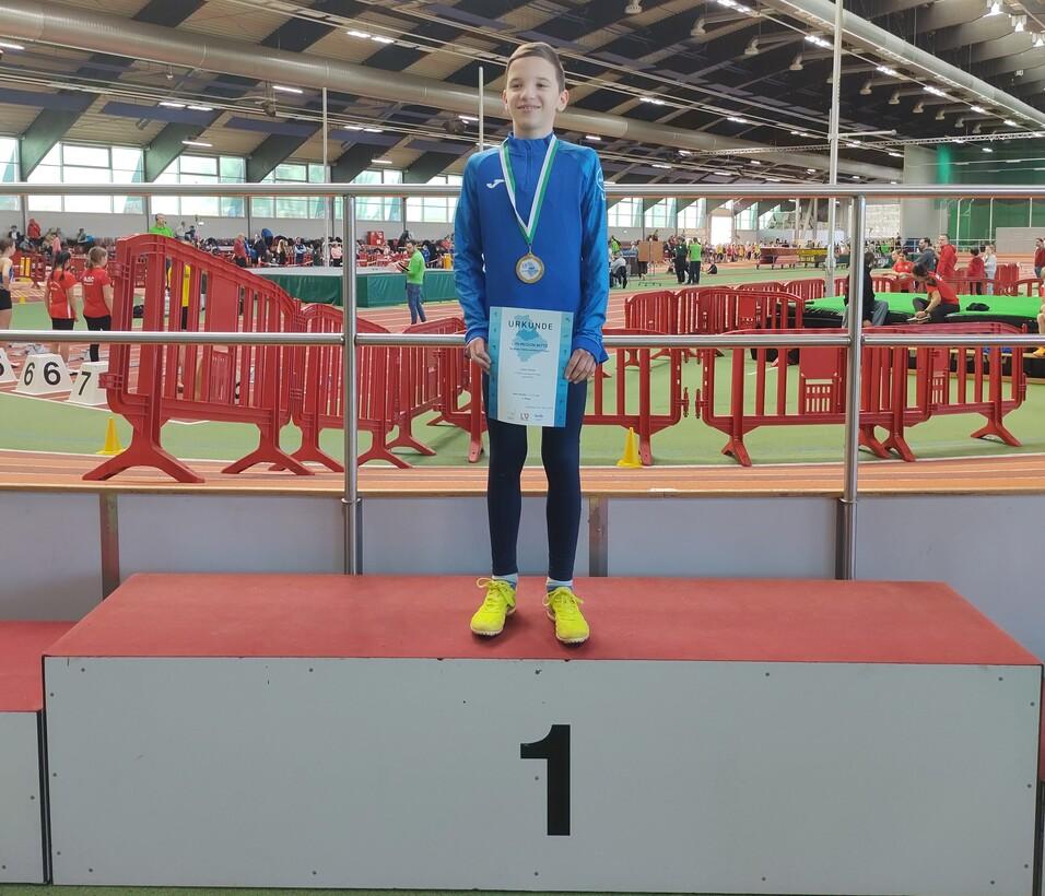 Junge mit Medaille und Urkunde auf dem Siegerpodest