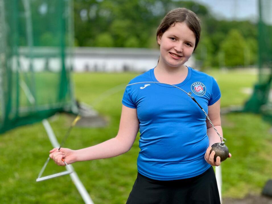 Leichtathletin zeigt ihr Sportger&auml;t, einen Hammer