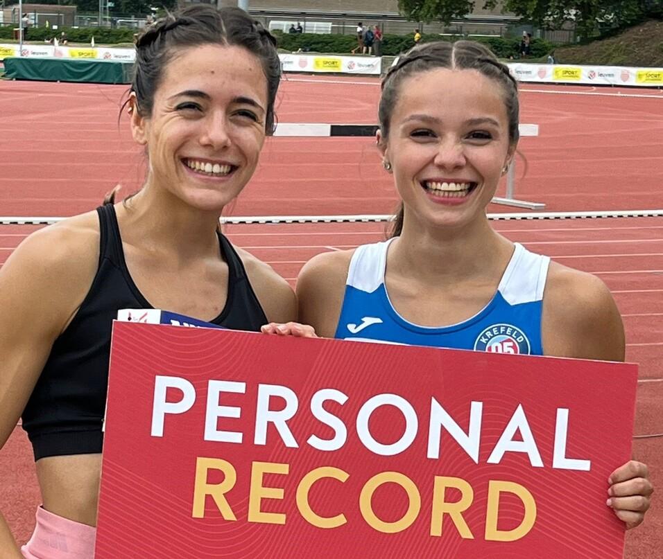 Zwei Sportlerinnen zeigen ein Schild f&uuml;r die pers&ouml;nliche Bestzeit