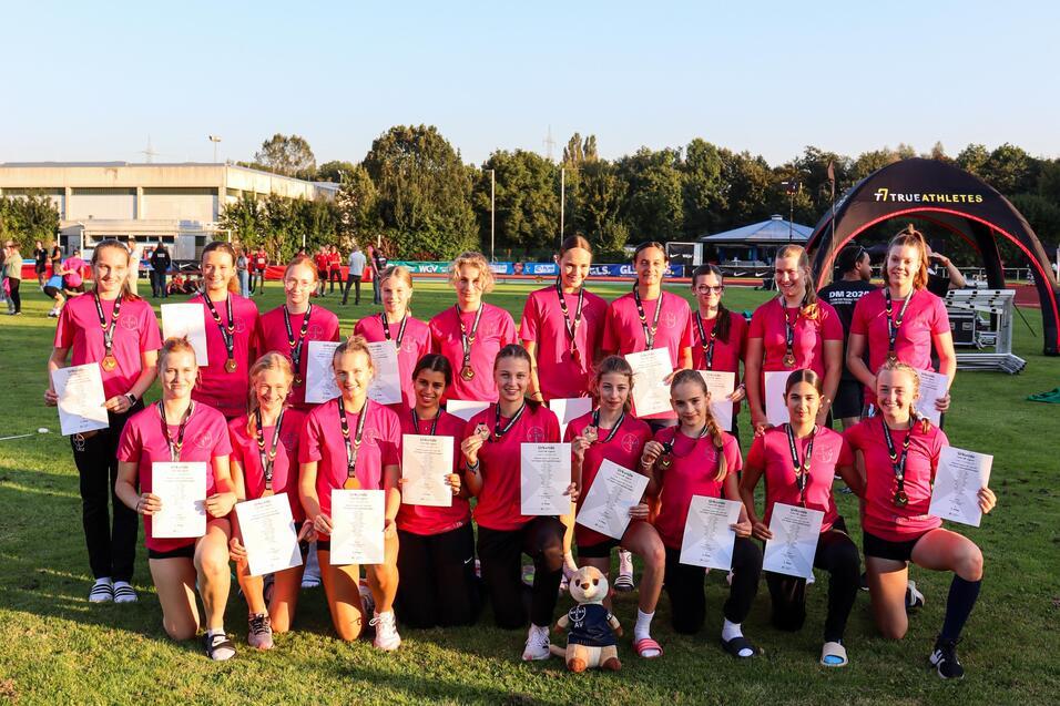 Team mit pinken Shirts und Urkunden