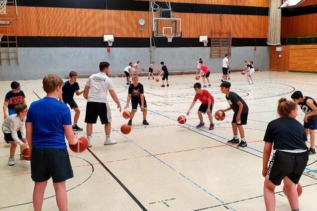 Viele Kinder dribbeln einen Basketball
