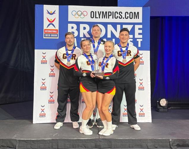 5 Sportler der Dolphins stehen im deutschen Nationaltrikot auf dem 3. Platz mit der Bronzemedaille