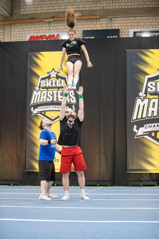 Ein Mann wirft eine Cheerleaderin in die Luft