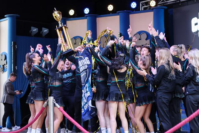 Cheerleading Team hält einen Pokal in den Händen