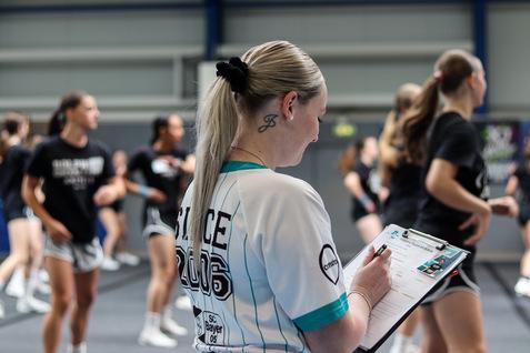 Eine Trainerin macht sich beim Cheerleading Notizen