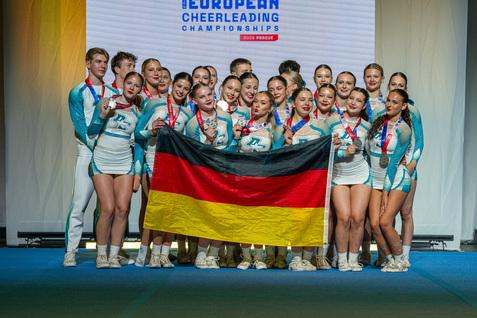 Die Cheerleader der Loony Dolphins freuen sich über die Silbermedaille und posieren mit der Deutschlandflagge