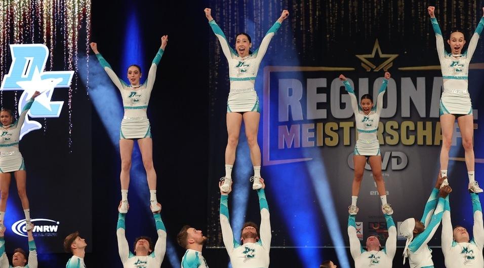 F&uuml;nf Cheerleading Frauen werden von M&auml;nnern getragen und strecken die Arme nach oben