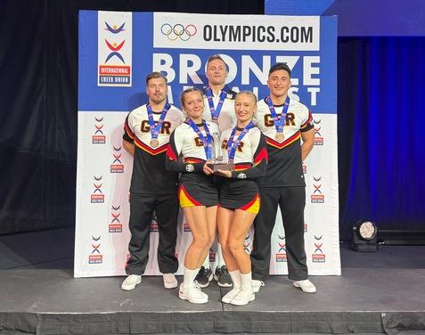 5 Sportler der Dolphins stehen im deutschen Nationaltrikot auf dem 3. Platz mit der Bronzemedaille