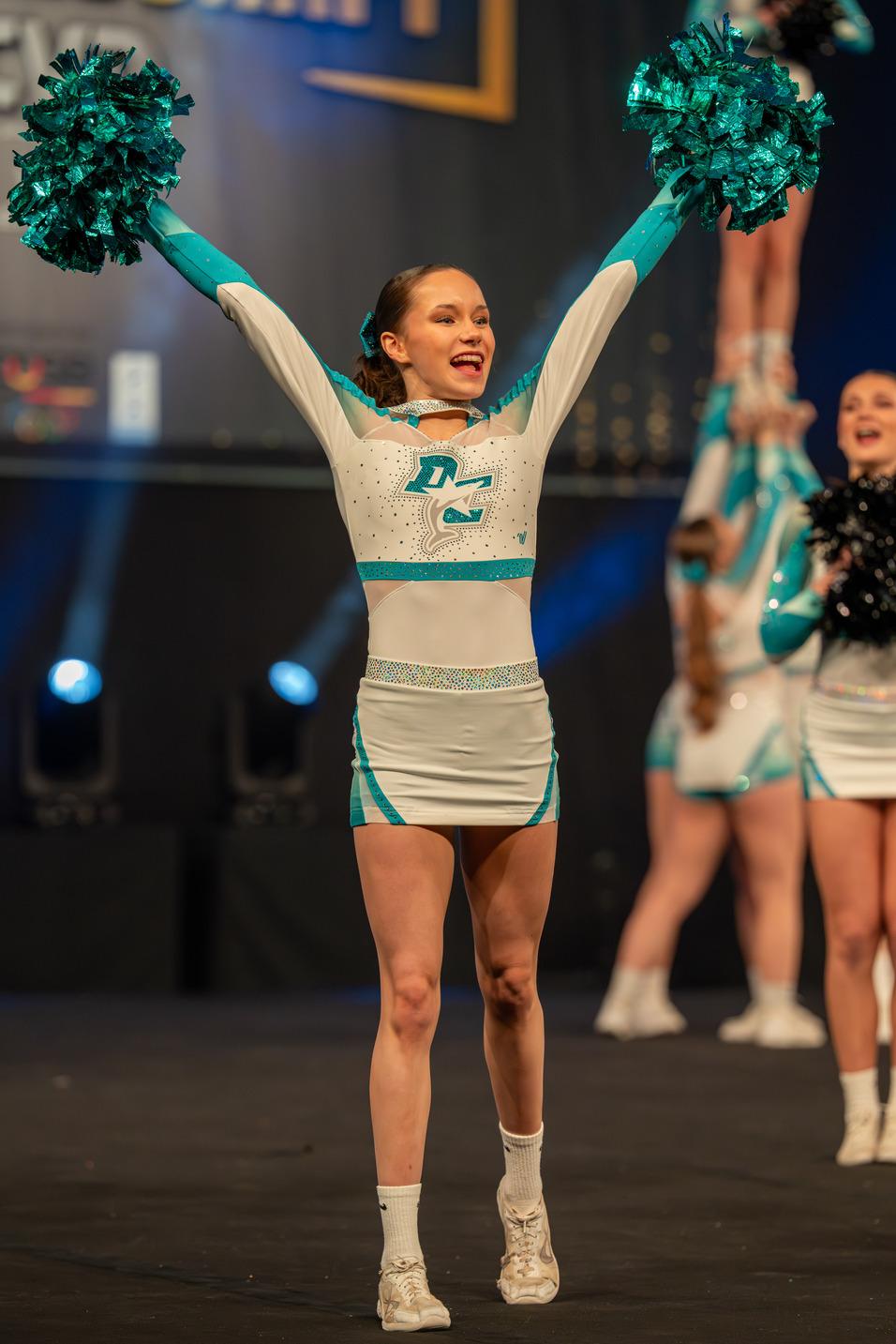 Eine Cheerleaderin streckt die Arme nach oben