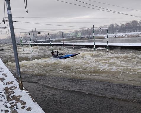 Kanute im blauen Kanu auf Wildwasserkanal