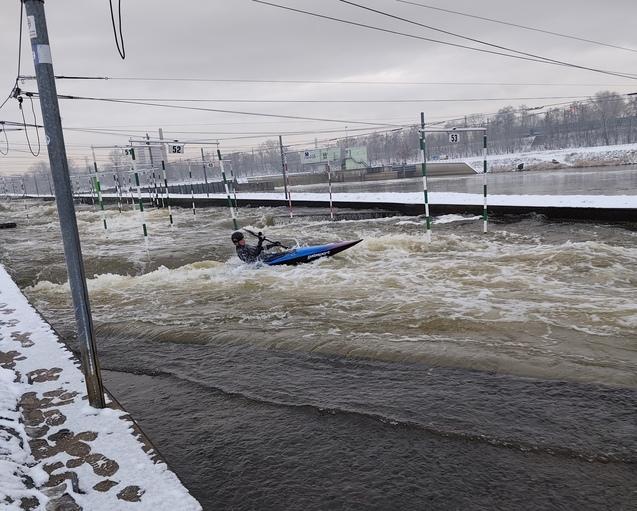 Kanute im blauen Kanu auf Wildwasserkanal