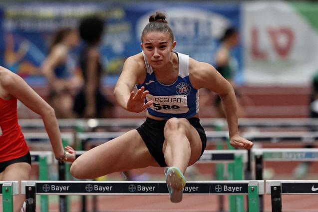 Junge Leichtathletin springt über Hürde