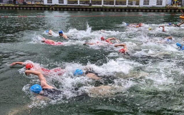 Zahlreiche Menschen schwimmen nebeneinander