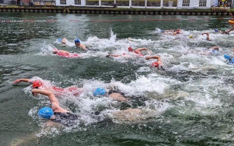 Zahlreiche Menschen schwimmen nebeneinander