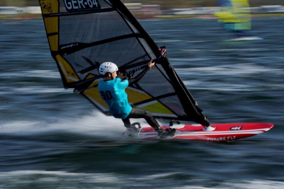 Windsurfer steht schräg auf seinem Board