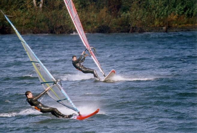 Zwei Windsurfer fahren nebeneinander