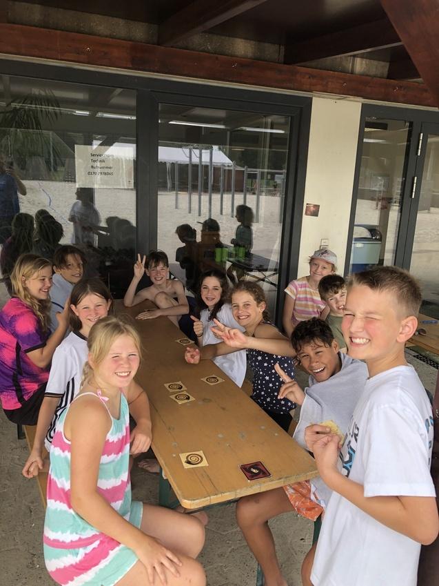 Neun Kinder spielen zusammen Karten